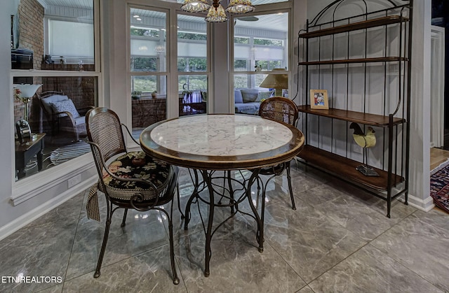 sunroom / solarium featuring a chandelier