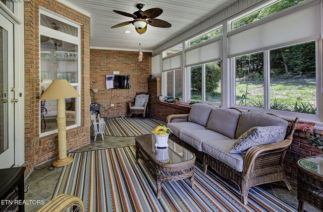 sunroom / solarium with ceiling fan and an outdoor living space