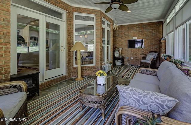 sunroom featuring brick wall, ceiling fan, crown molding, and an outdoor hangout area