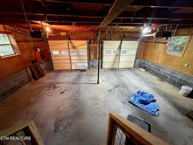 garage with concrete block wall and a garage door opener
