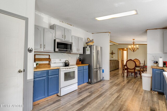 776 Salem Valley Rd, Ten Mile, TN 37880 - kitchen with stainless steel appliances, blue cabinets, a chandelier, light wood-style floors, and pendant lighting