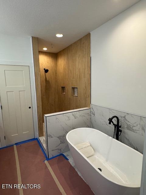 273 Sugar Maple Ct, Madisonville, TN 37354 - bathroom with recessed lighting, a freestanding tub, walk in shower, tile walls, and wainscoting
