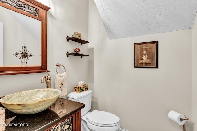 714 Cambridge Crest Ln, Knoxville, TN 37919 - half bathroom featuring a textured ceiling, toilet, vanity, and lofted ceiling