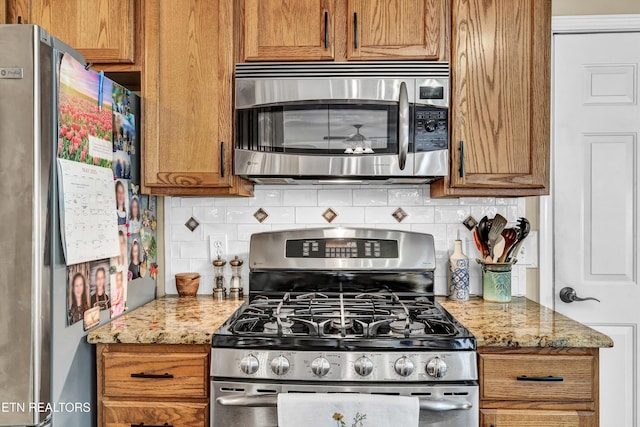 714 Cambridge Crest Ln, Knoxville, TN 37919 - kitchen with stainless steel appliances, brown cabinets, tasteful backsplash, and light stone countertops
