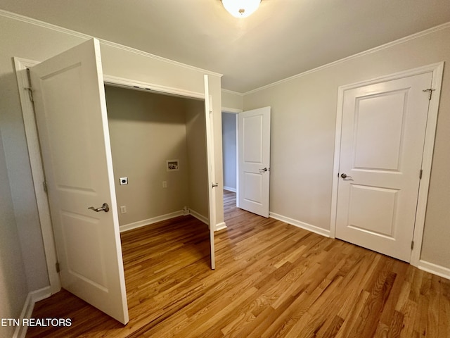 unfurnished bedroom featuring light wood-style floors, baseboards, and crown molding