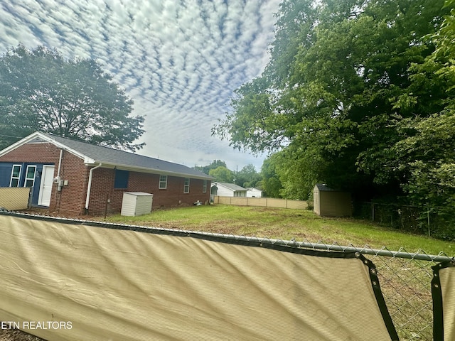 view of property exterior with a storage unit, brick siding, and an outbuilding