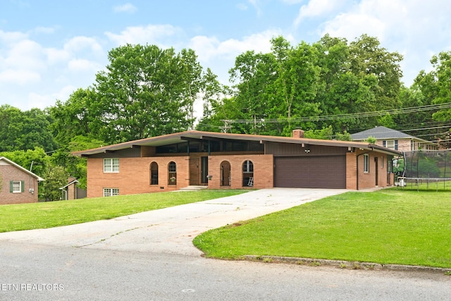 8000 Berkshire Blvd, Powell, TN 37849 - mid-century home featuring a trampoline, a front lawn, a chimney, an attached garage, and brick siding