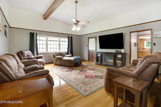 8000 Berkshire Blvd, Powell, TN 37849 - living area featuring light wood finished floors, a ceiling fan, a glass covered fireplace, beamed ceiling, and a decorative wall