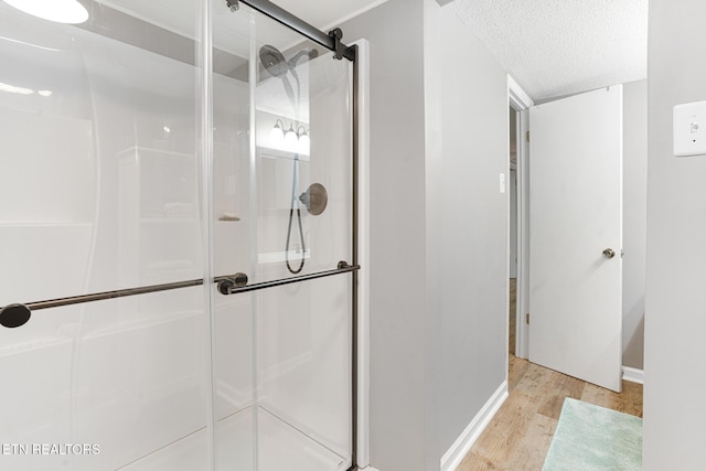 8000 Berkshire Blvd, Powell, TN 37849 - full bath with wood finished floors, a shower stall, a textured ceiling, and baseboards