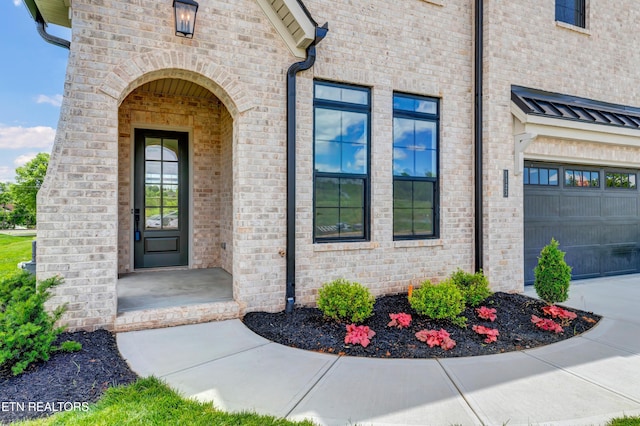 1123 Branch Hook Rd, Knoxville, TN 37934 - view of exterior entry with brick siding, concrete driveway, and a garage