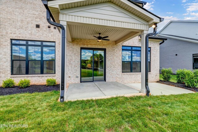 1123 Branch Hook Rd, Knoxville, TN 37934 - view of exterior entry with ceiling fan, a lawn, a patio, and brick siding