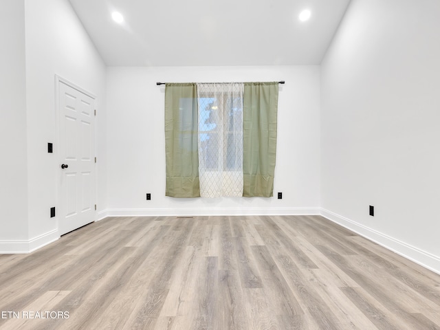 unfurnished room featuring vaulted ceiling, baseboards, wood finished floors, and recessed lighting
