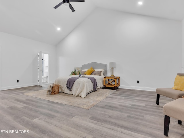 bedroom featuring high vaulted ceiling, wood finished floors, baseboards, recessed lighting, and ensuite bathroom
