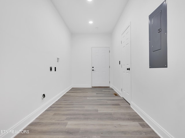 washroom featuring electric panel, light wood finished floors, baseboards, and recessed lighting