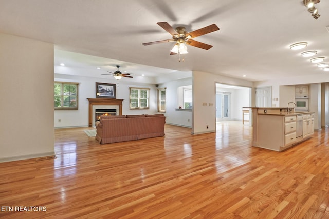 11 Kingsboro Ln, Crossville, TN 38558 - unfurnished living room with light wood-type flooring, a tile fireplace, ceiling fan, a sink, and recessed lighting