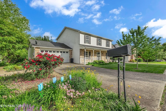 traditional-style home with a porch, a garage, concrete driveway, a front lawn, and stone siding