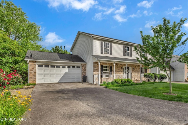 traditional-style home featuring a porch, asphalt driveway, a front yard, an attached garage, and brick siding