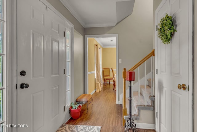 entrance foyer featuring stairs, wood finished floors, and ornamental molding