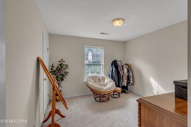 sitting room featuring carpet floors and baseboards