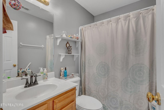 full bathroom featuring toilet, vanity, and a shower with curtain