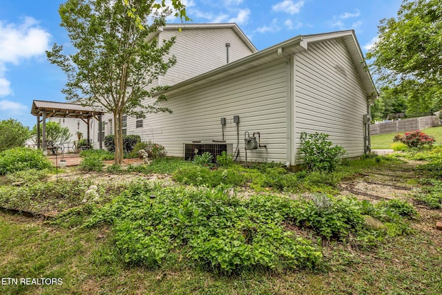 rear view of house with a gazebo, central AC, and fence