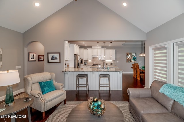 109 Niwodihi Trl, Vonore, TN 37885 - living room with high vaulted ceiling, dark wood finished floors, arched walkways, baseboards, and recessed lighting