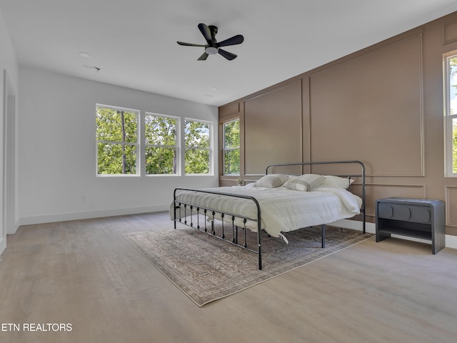 1715 Serene Cove Way, Knoxville, TN 37920 - bedroom with multiple windows, wood finished floors, a decorative wall, a ceiling fan, and baseboards