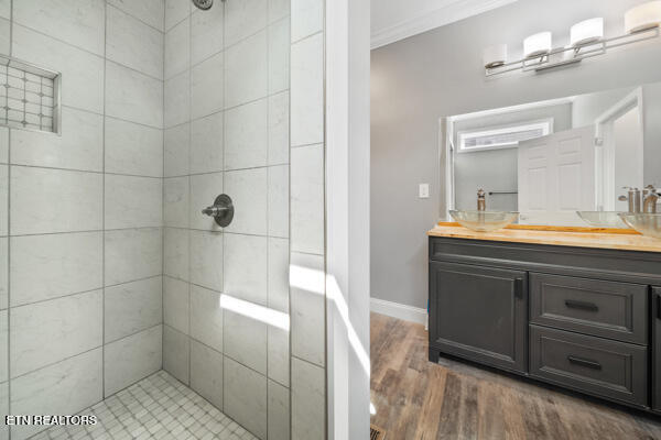 3966 Mountain Vista Rd, Knoxville, TN 37931 - bathroom featuring a tile shower, vanity, wood finished floors, ornamental molding, and baseboards