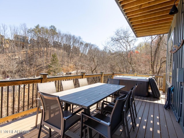 deck with outdoor dining space and a hot tub
