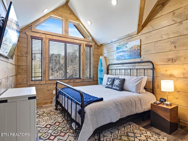 bedroom featuring wooden walls, lofted ceiling, wood finished floors, and recessed lighting