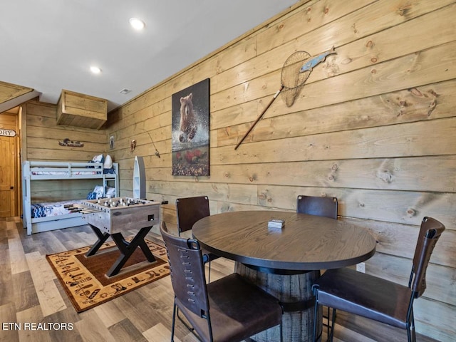 dining space featuring wooden walls, wood finished floors, and recessed lighting
