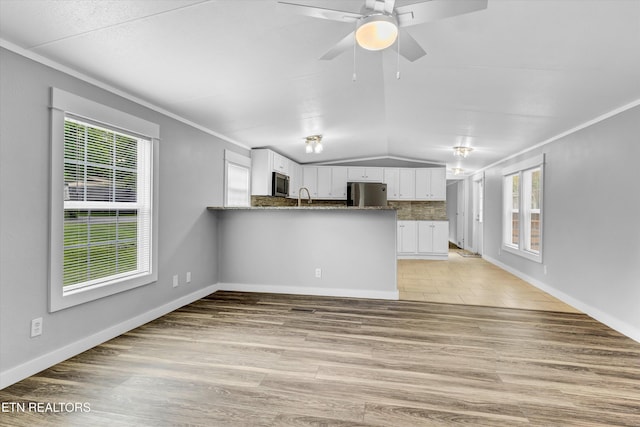 180 County Rd 853, Delano, TN 37325 - unfurnished living room with vaulted ceiling, a ceiling fan, light wood-type flooring, a sink, and crown molding