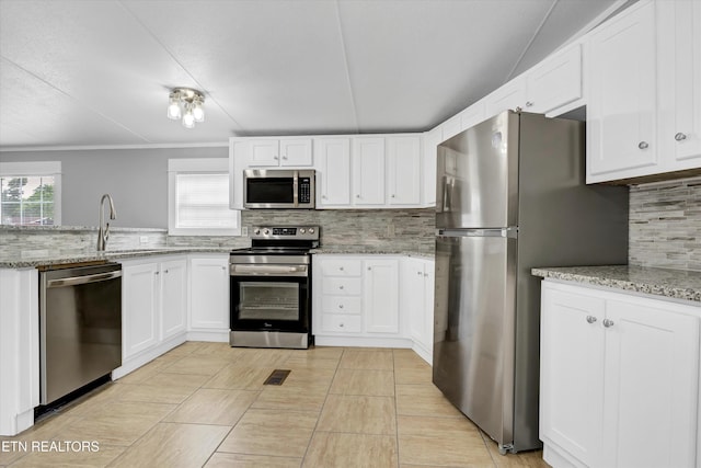 180 County Rd 853, Delano, TN 37325 - kitchen featuring stainless steel appliances, decorative backsplash, white cabinetry, crown molding, and light stone countertops