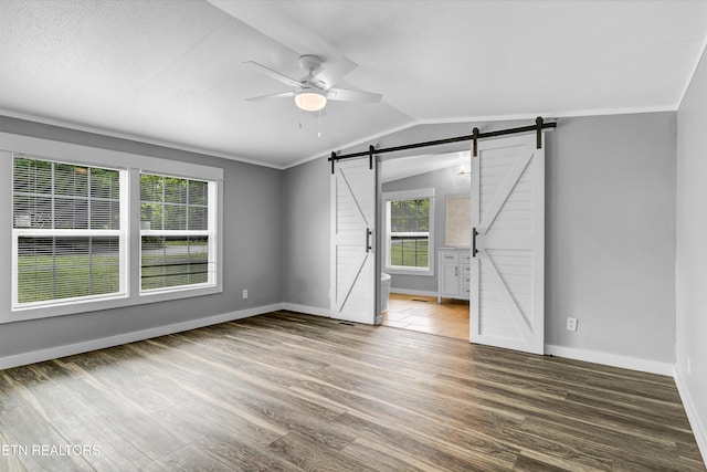 180 County Rd 853, Delano, TN 37325 - empty room with a barn door, ceiling fan, wood finished floors, baseboards, and vaulted ceiling