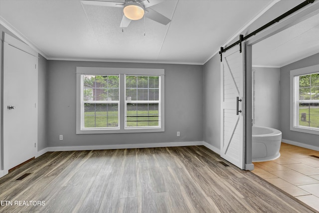 180 County Rd 853, Delano, TN 37325 - unfurnished bedroom featuring a barn door, wood finished floors, baseboards, ornamental molding, and ceiling fan