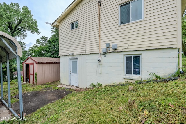 rear view of property featuring a storage unit and an outdoor structure