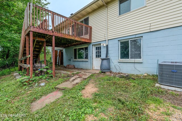rear view of property featuring central air condition unit, a wooden deck, and stairs