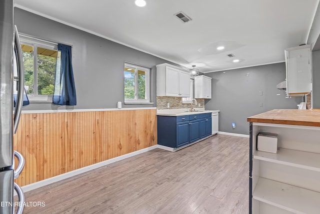 kitchen with light wood-type flooring, blue cabinetry, recessed lighting, healthy amount of natural light, and crown molding