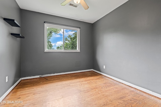 unfurnished room with a ceiling fan, wood finished floors, and baseboards