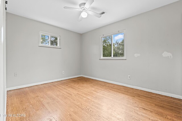 unfurnished room featuring healthy amount of natural light, light wood-type flooring, baseboards, and ceiling fan