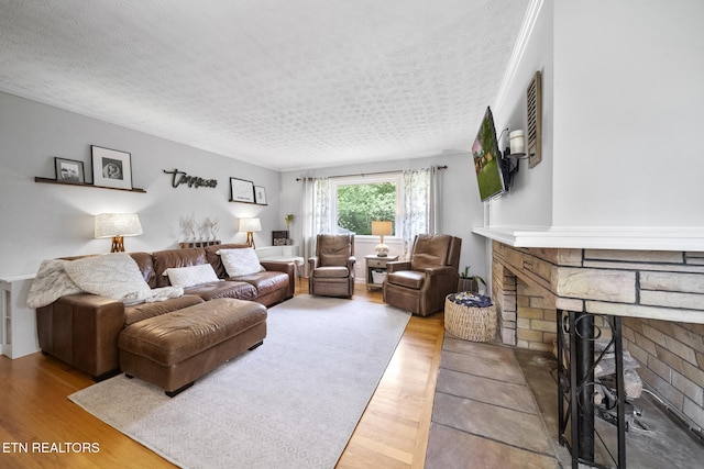 living room featuring wood finished floors, a fireplace, and a textured ceiling