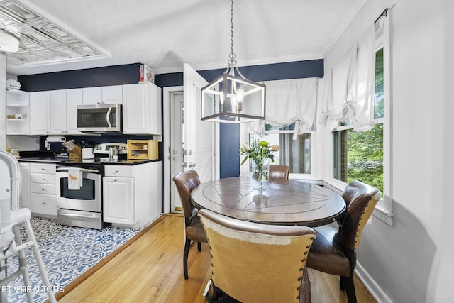 dining area featuring light wood-style flooring, a chandelier, and baseboards