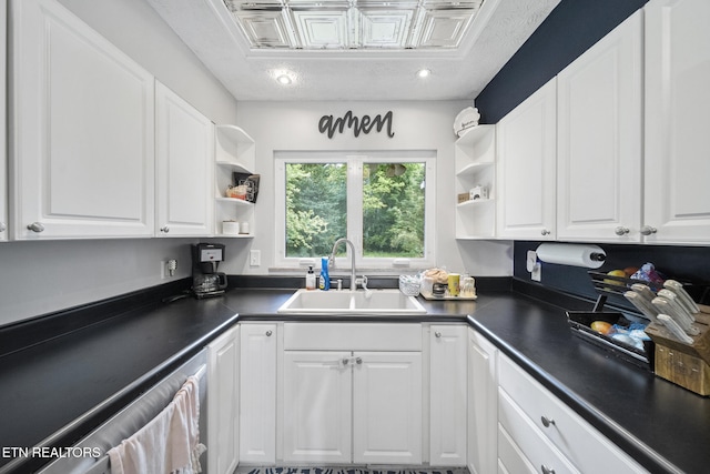 kitchen with a sink, open shelves, dark countertops, and white cabinets
