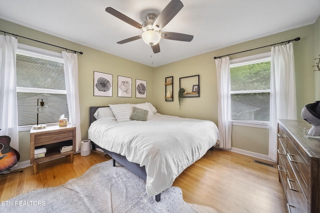 bedroom featuring baseboards, light wood finished floors, and a ceiling fan