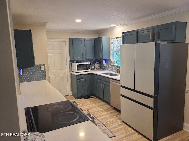 131 Chestnut Hill Rd, Oak Ridge, TN 37830 - kitchen featuring freestanding refrigerator, white microwave, a sink, stainless steel dishwasher, and light countertops