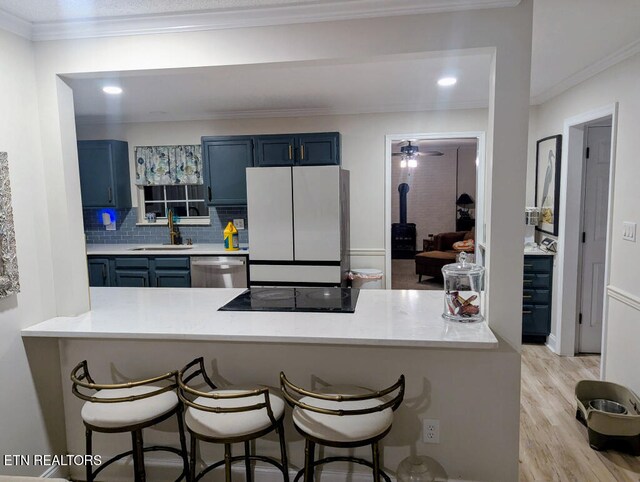 131 Chestnut Hill Rd, Oak Ridge, TN 37830 - kitchen featuring freestanding refrigerator, blue cabinets, a sink, black electric stovetop, and ornamental molding