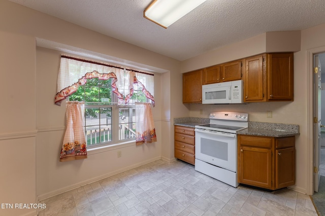 122 Mariners Dr, Crossville, TN 38558 - kitchen with white appliances, brown cabinets, baseboards, a textured ceiling, and dark stone countertops