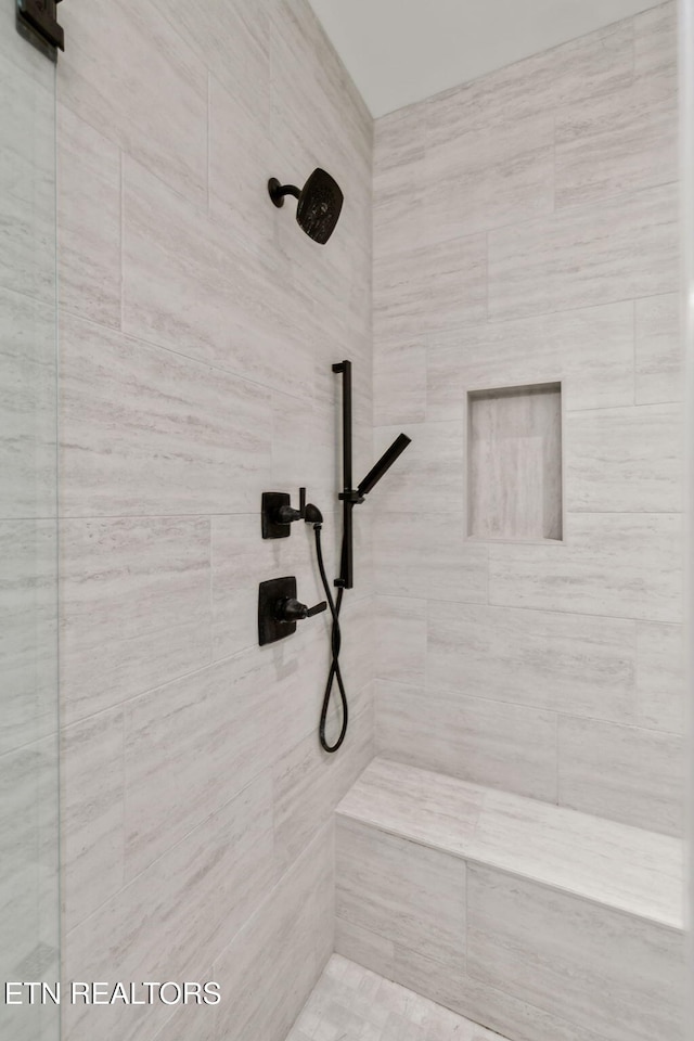 full bath with a tile shower