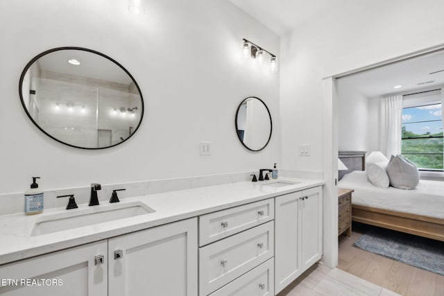 full bath with double vanity and wood finished floors