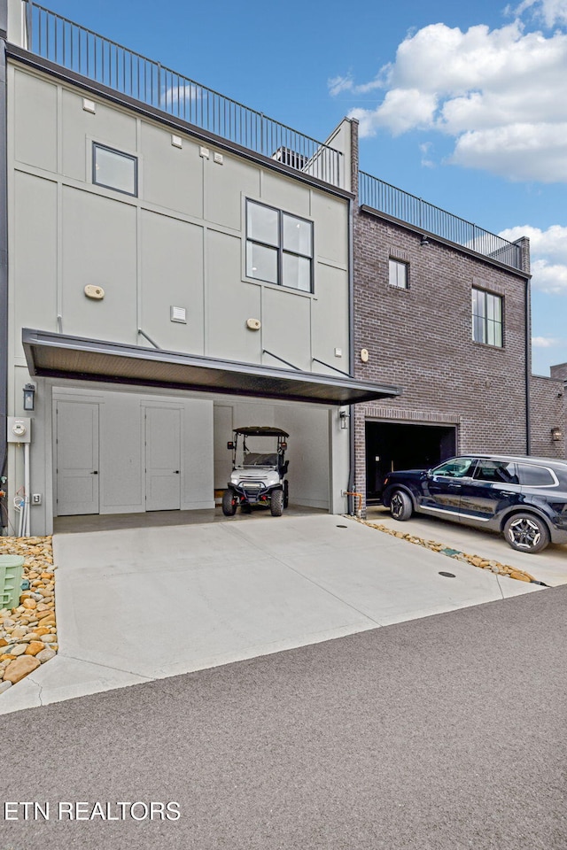 view of building exterior featuring concrete driveway and a garage